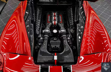 Detailer carefully cleaning a cool engine bay with a soft brush and low-pressure spray while protecting sensitive electrical components.